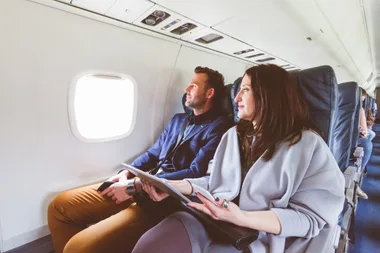 A mature couple on a plane looking out the window