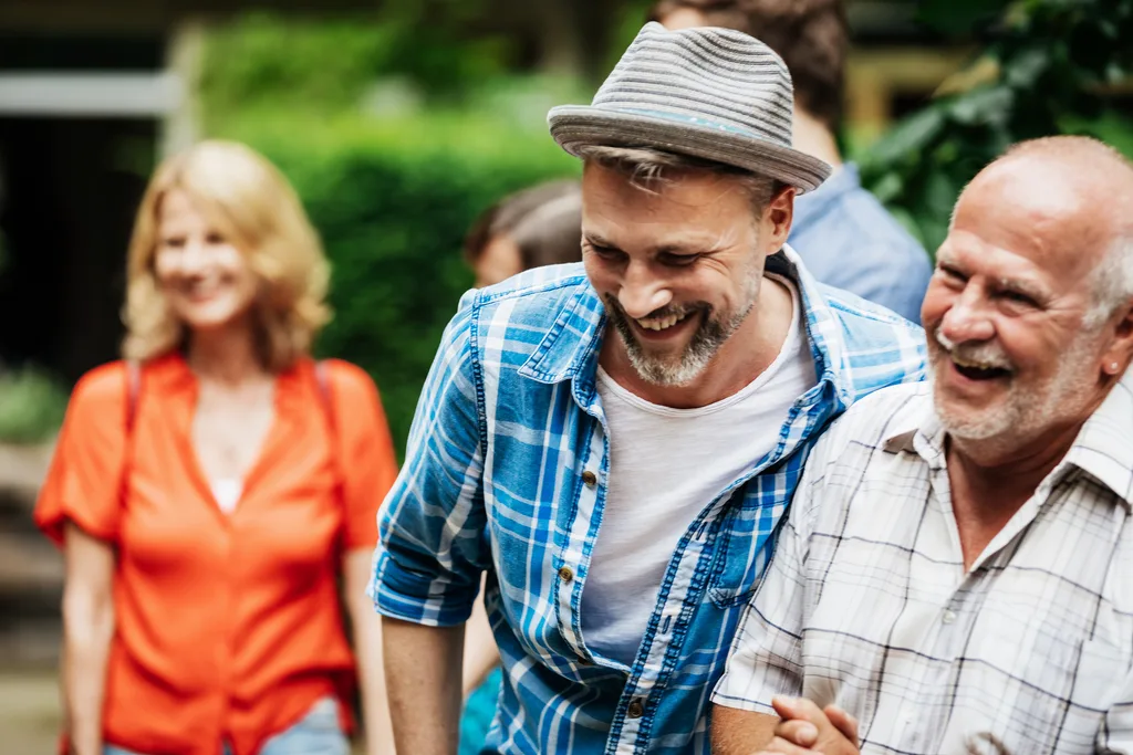 Casually dressed men laughing at a garden party