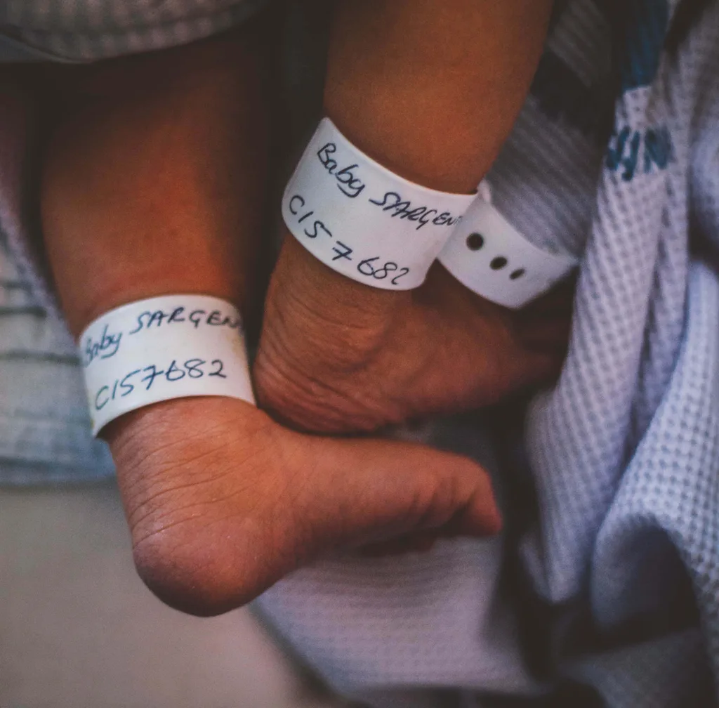 A baby with a hospital name tag