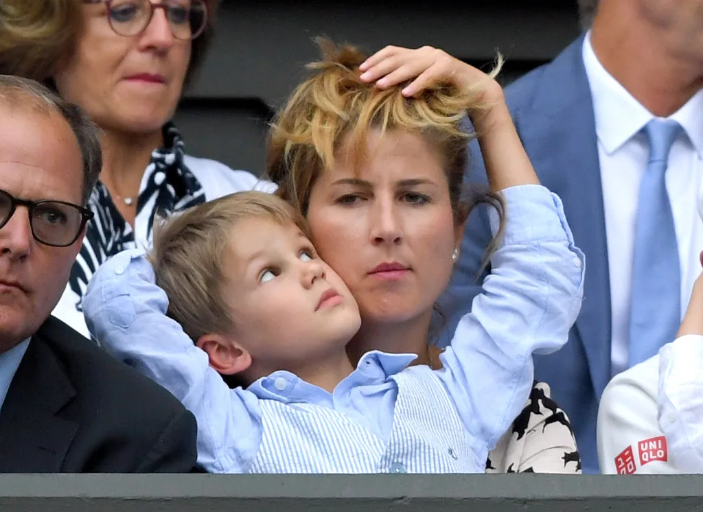 Mirka Federer's son putting his arms around Mirka's face