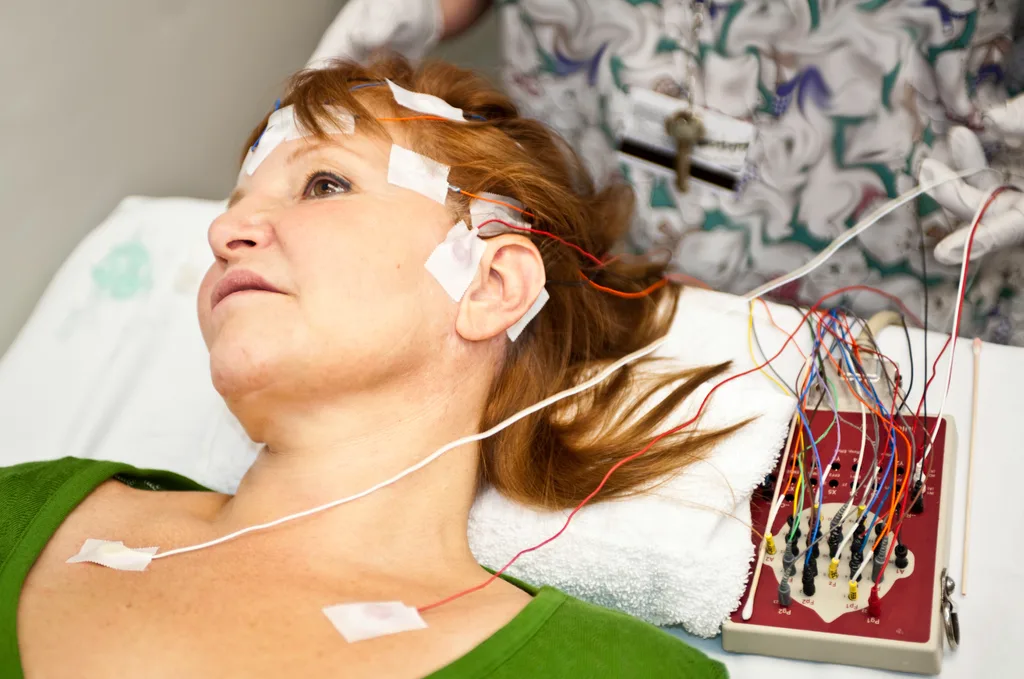 A woman lying in a hospital bed with a EEG measuring tape