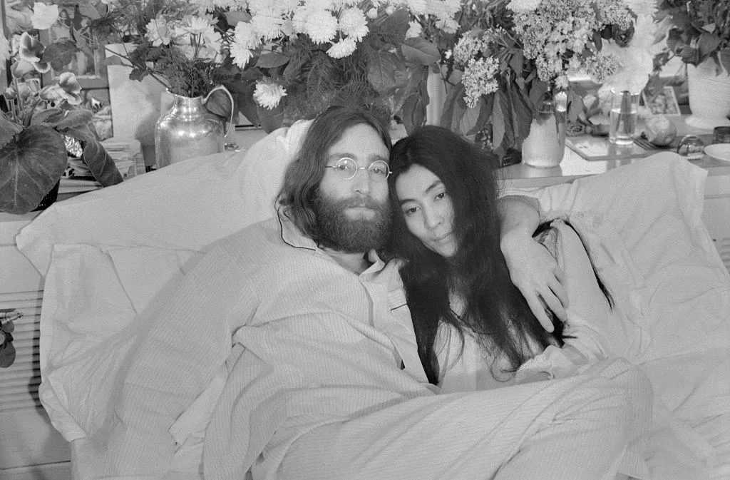 A black and white photograph of John Lennon and Yoko Ono