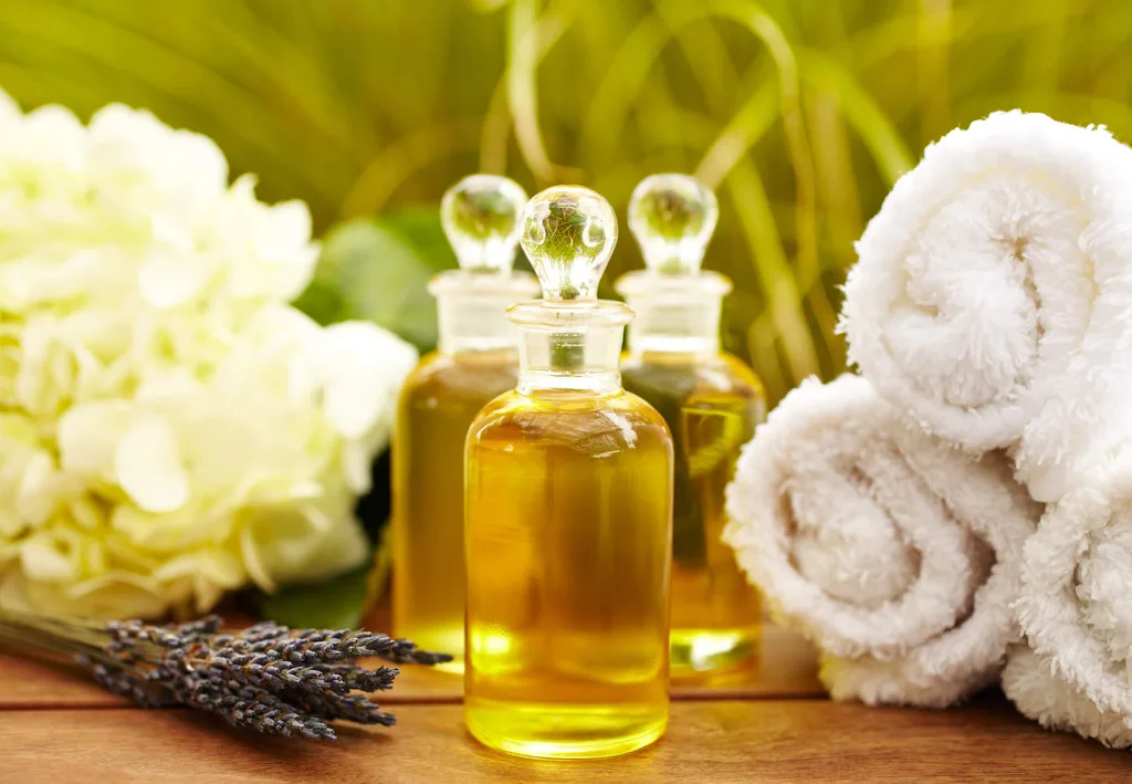 Bottles of massage oil with towels and lavender