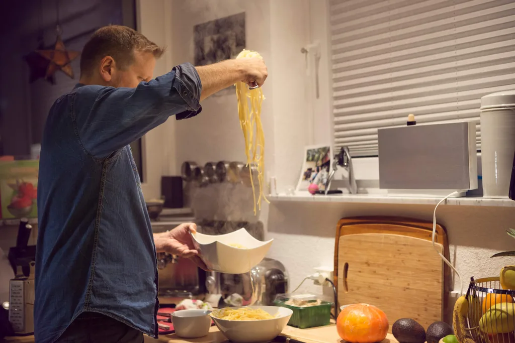A man cooking pasta in a kitchen