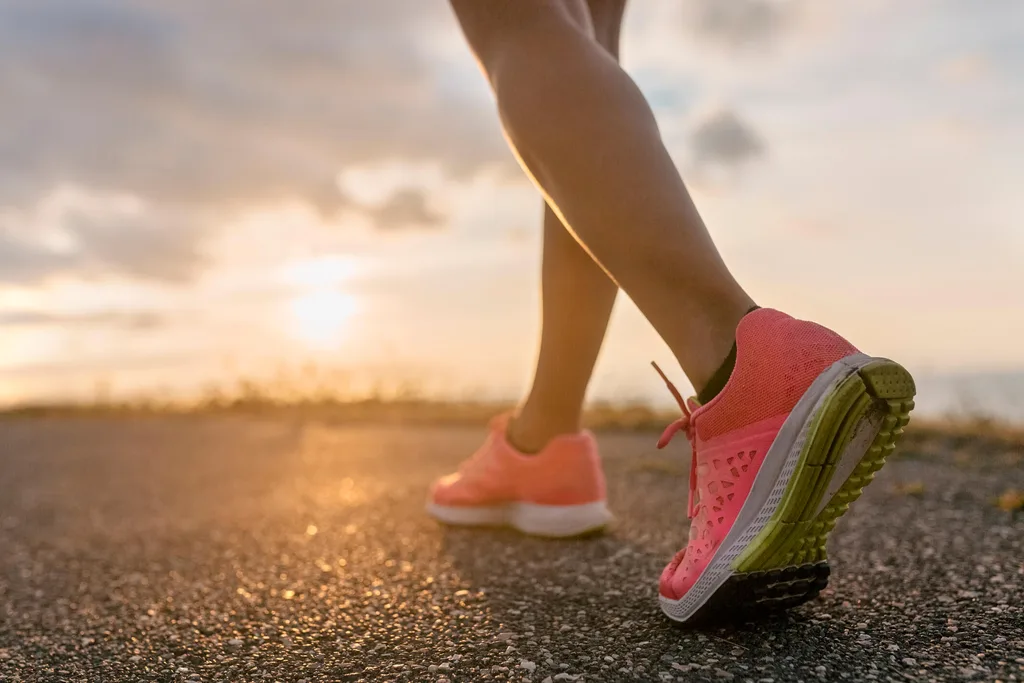 A woman running at the beach in running shoes