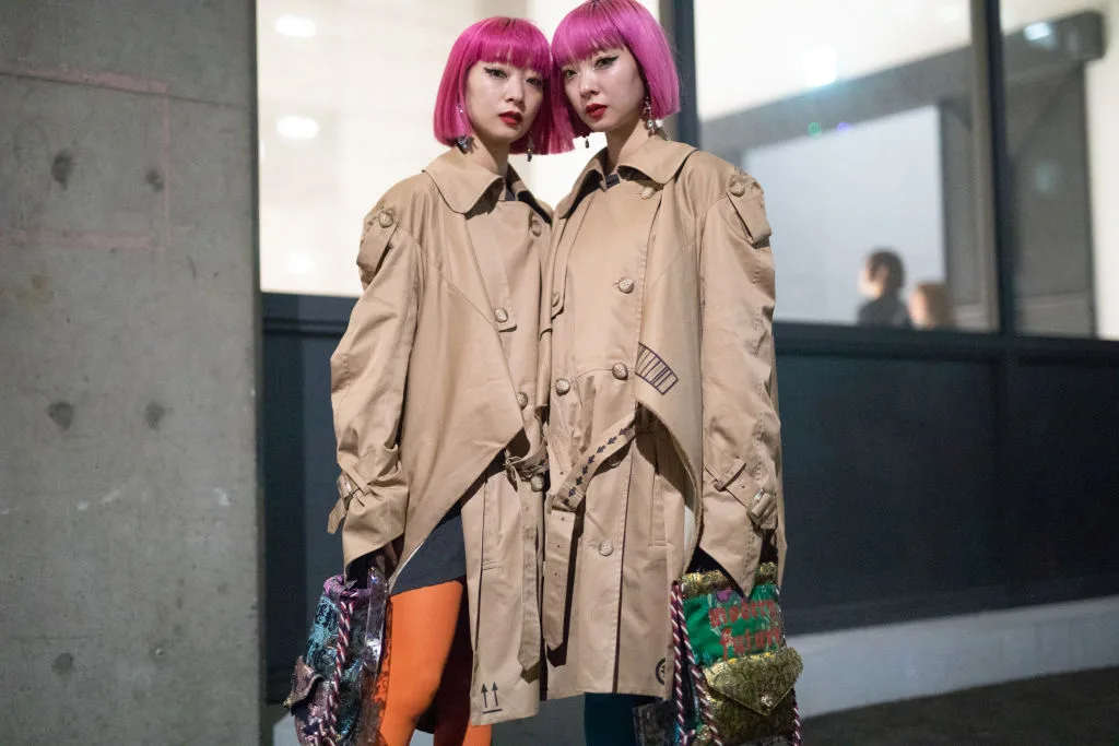 Two girls with pink hair dressed up in Japanese street fashion