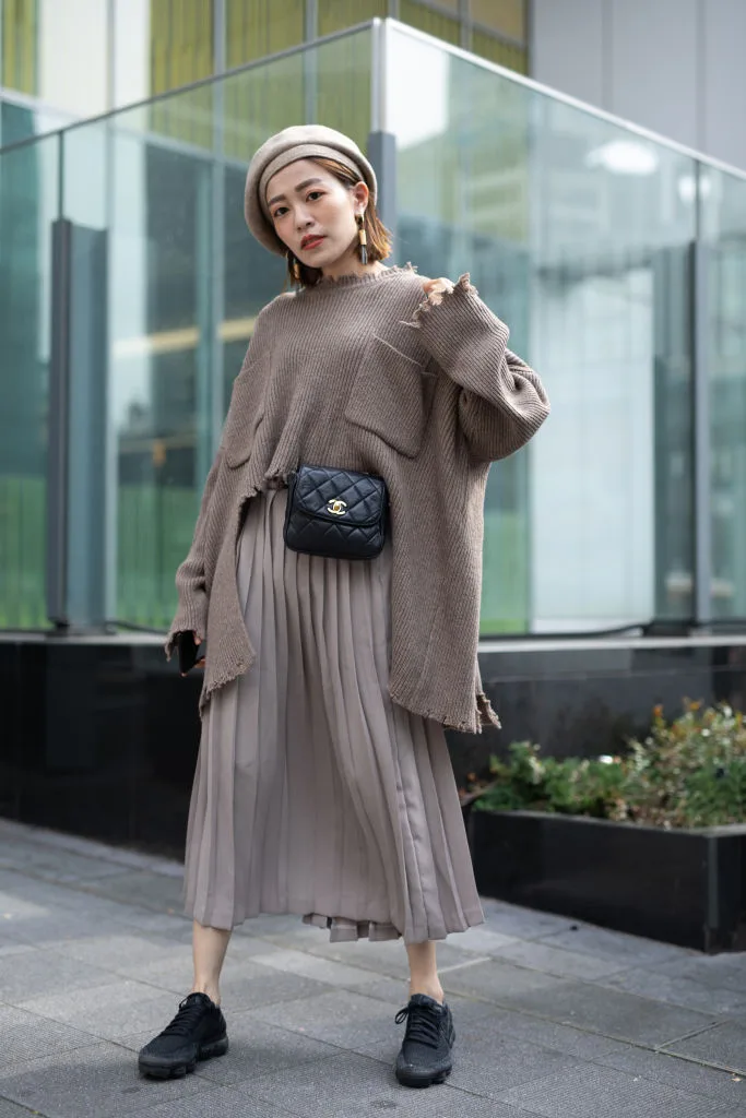 A woman at Tokyo Fashion week wearing a taupe outfit with beret and handbag
