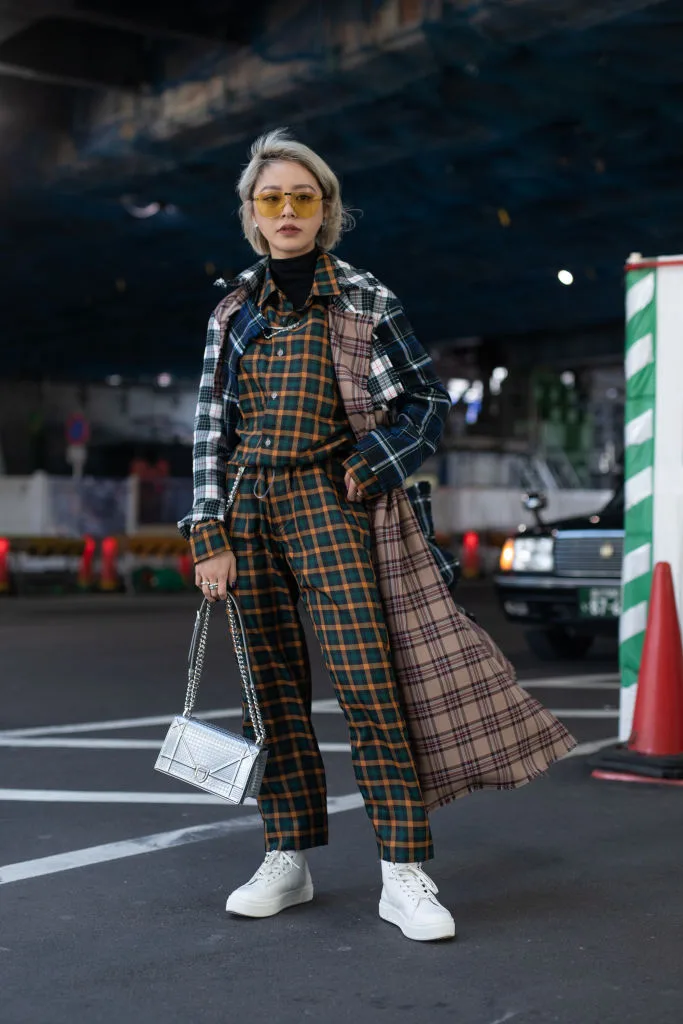 A guest at the Amazon Fashion Week TOKYO wearing a green and yellow jumpsuit