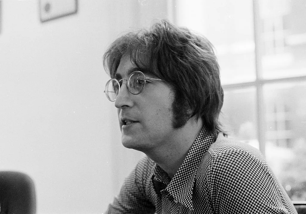 A black and white image of John Lennon during an interview with Beat Instrument magazine