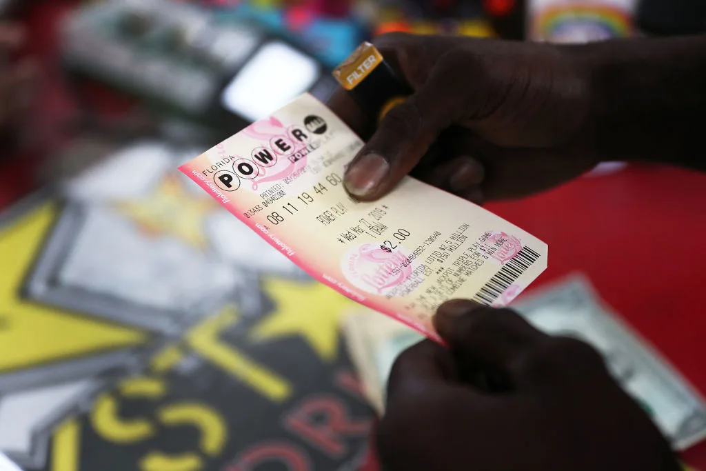 A man holding a powerball ticket in a newsagency