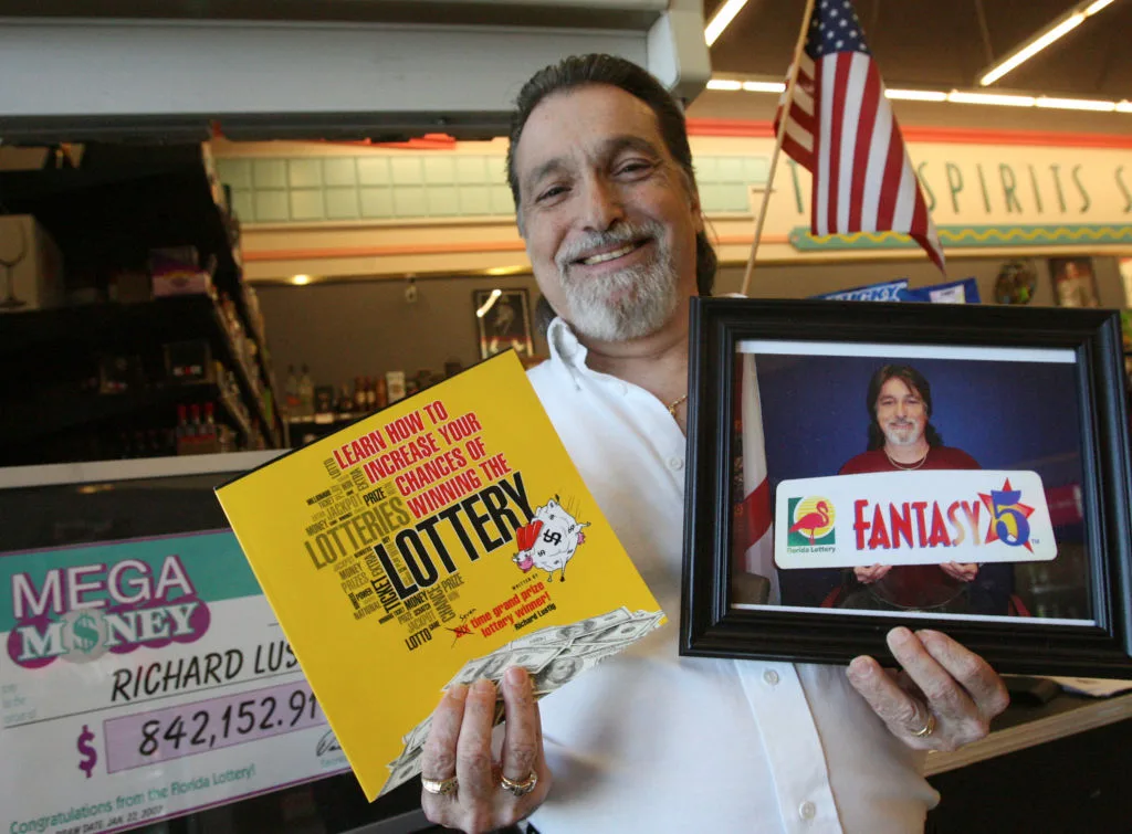 Richard Lustig holding a photo of himself winning the lottery