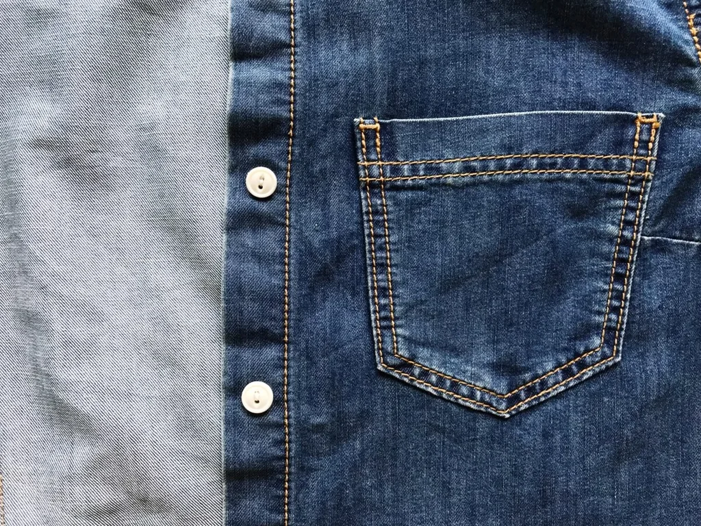 A close up photo of a denim jacket with a pocket