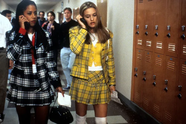 Stacey Dash and Alicia and Silverstone in plaid outfits in a school hallway