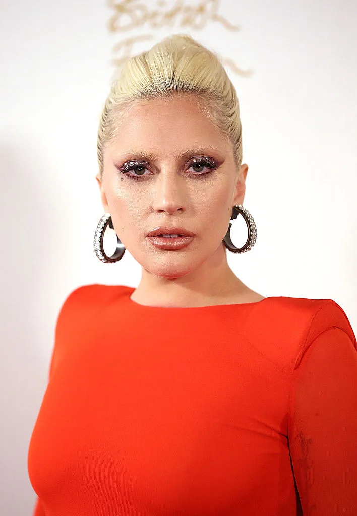 Lady Gaga in an orange top and earrings at the British fashion Awards of 2015