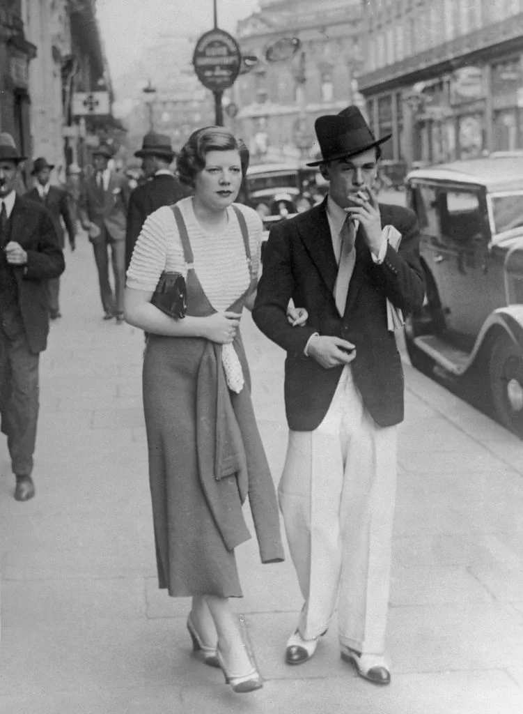 A black and white photograph of John Amery and his fiance walking down the streets of London