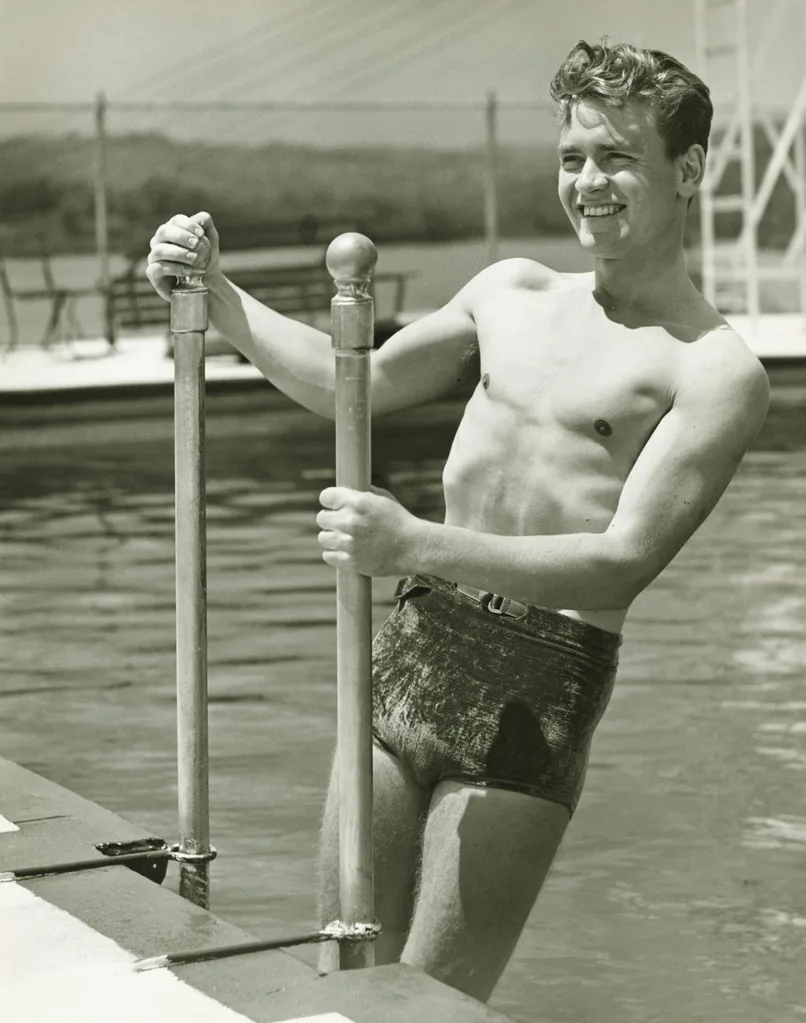 A man in elastic shorts climbing out of a pool