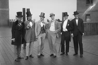A black and white photograph of well dressed men in suits and tophats