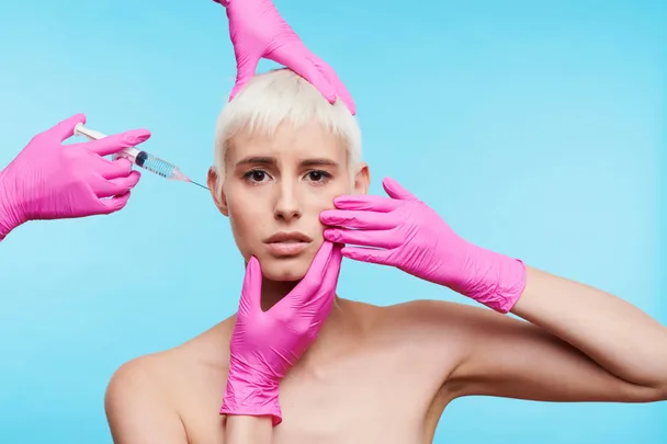 A woman getting a botox injection against a light blue background
