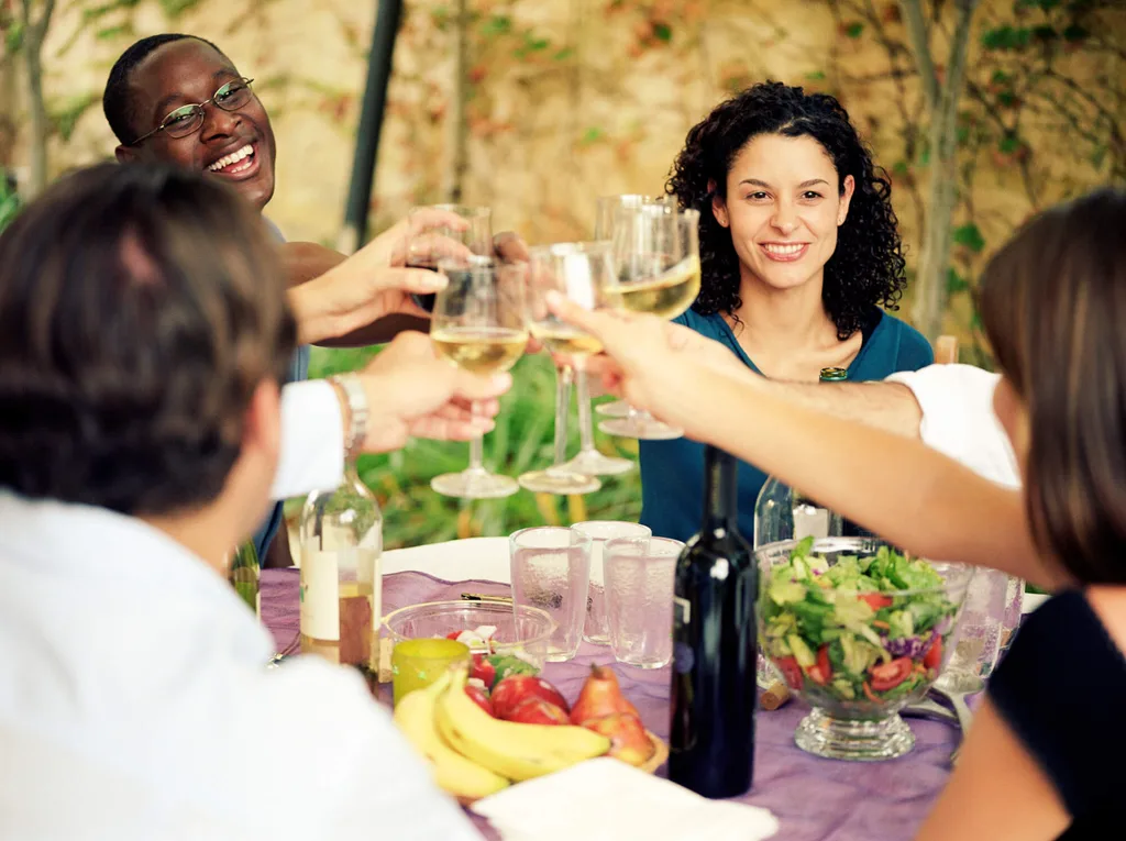 Friends toasting drinks around a table