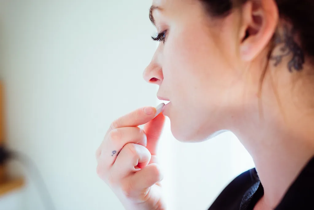 Woman taking tablet for heartburn