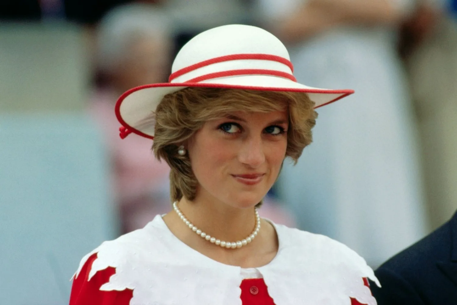 princess diana in a white and red outift and hat with a pearl necklance and earrings