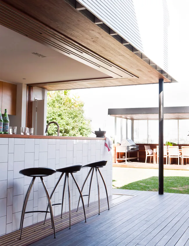 Turn your kitchen island into a bar with high stools that your friends can sit on while you pour the drinks.