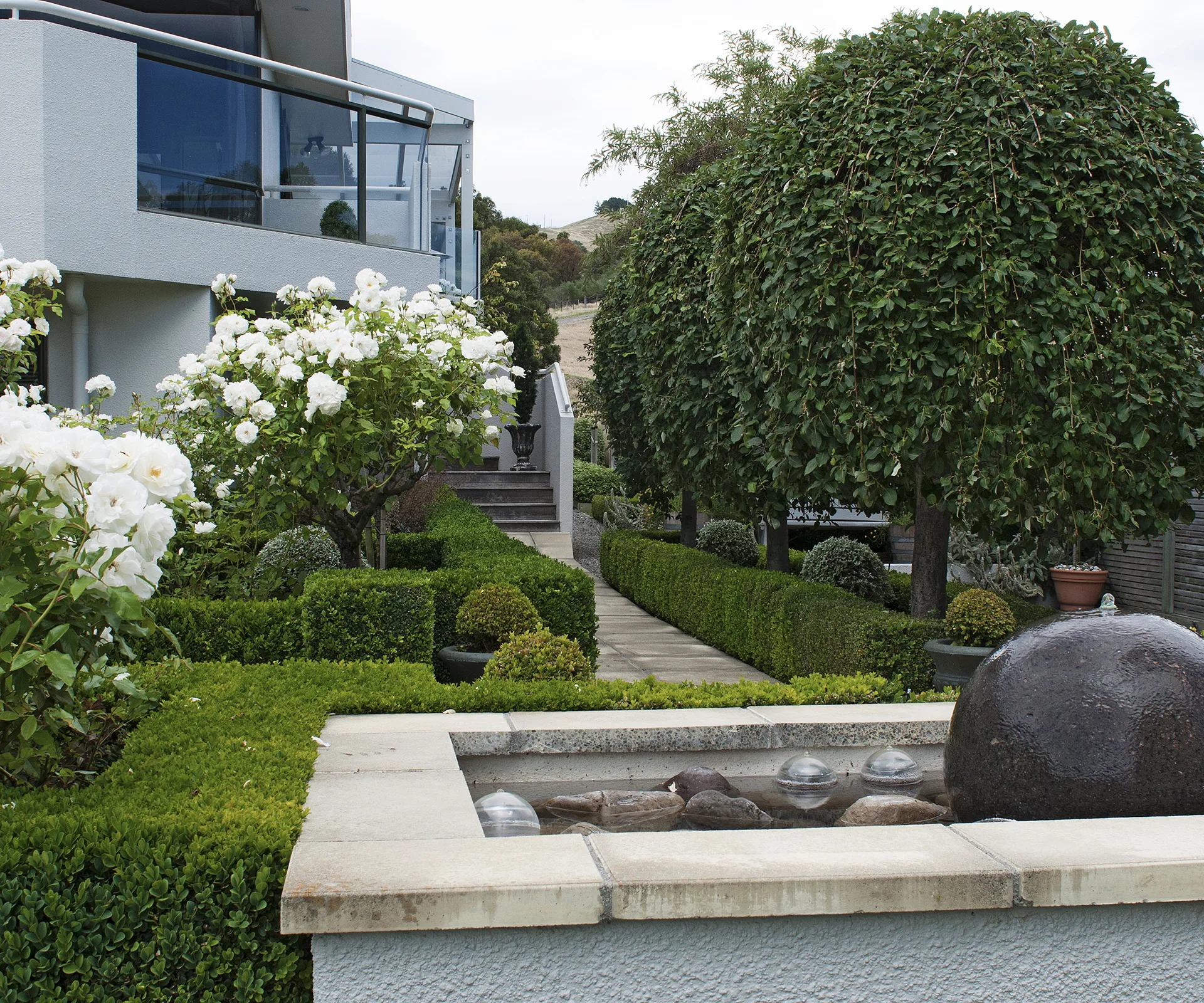 A gently bubbling water feature greets visitors on their way to the front door.