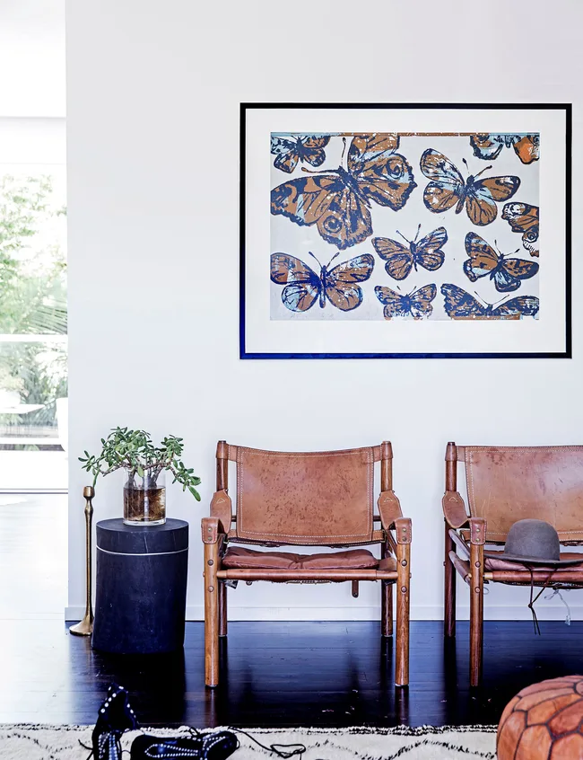 The home features safari chairs and butterfly artwork.
