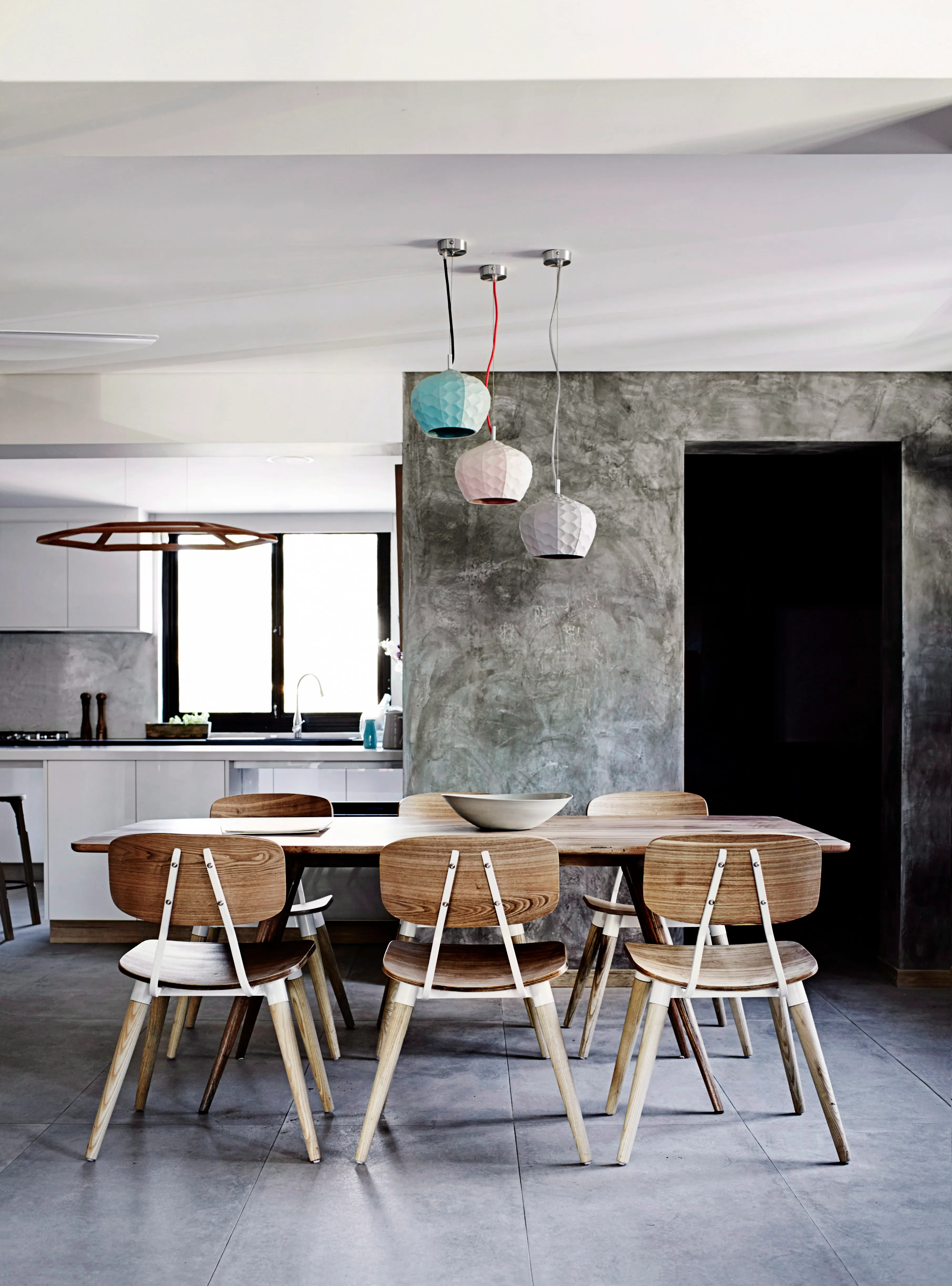 “Our dining area has a blend of modern, masculine features, combined with feminine, textural features,” says Matt. Coupled with the bold painting, the sinuous ceramic pendants add whimsy, while the rendered walls lend an industrial touch.