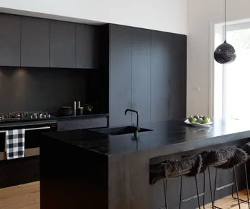 A matte black kitchen makes a bold statement in this Auckland villa
