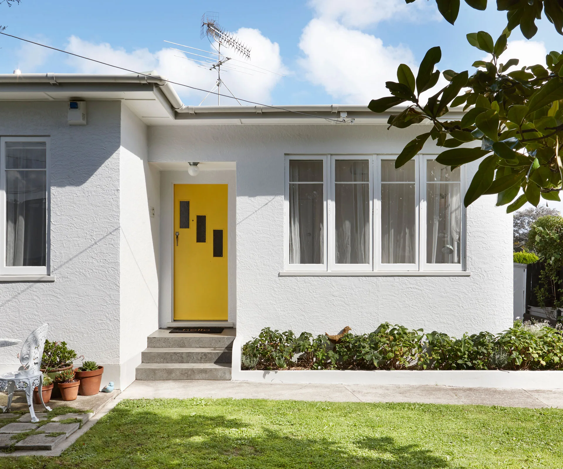 A concrete cottage in Auckland is softened with mid-century vibes