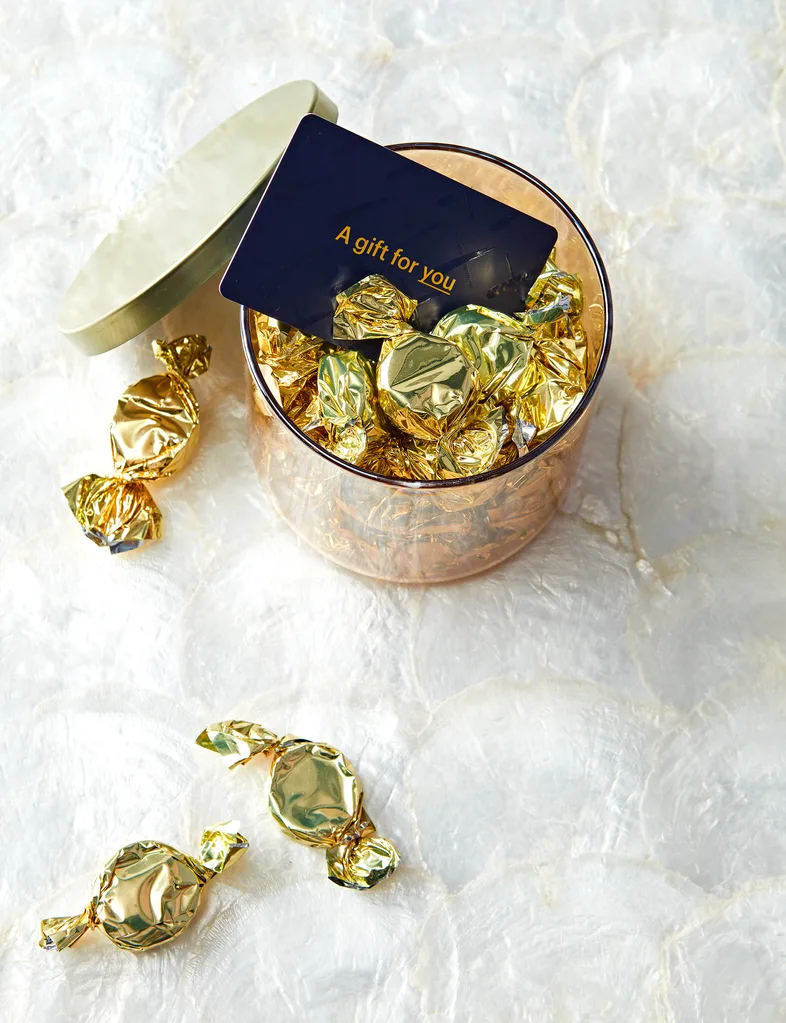 A gift voucher sitting inside a small cannister