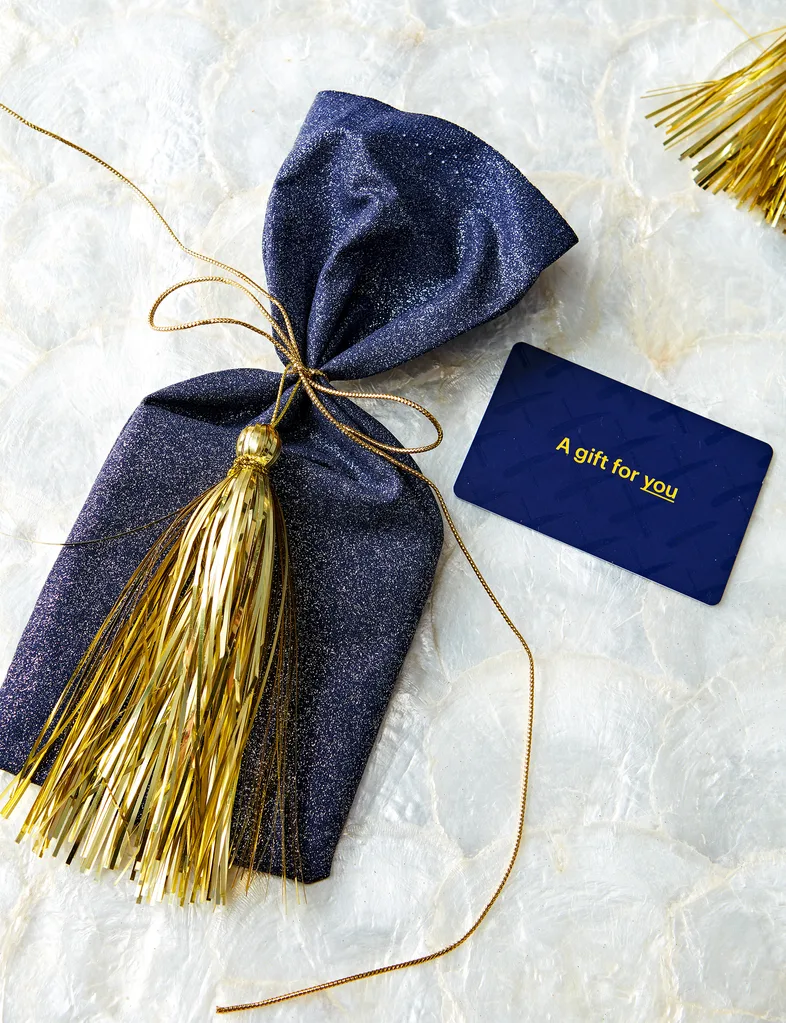 A gift voucher with a small bag decorated with tinsel