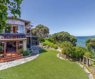 Enjoy views of Rangitoto at this iconic clifftop estate in Milford