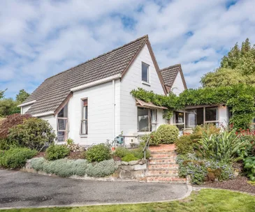This architecturally designed 70s home is surrounded by a lush garden