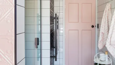 A pink doorway in the black and white bathroom