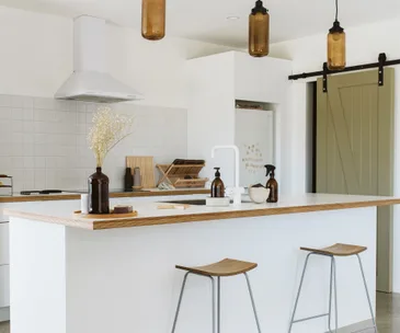 This black-barn style New Plymouth home has the cutest pink front door
