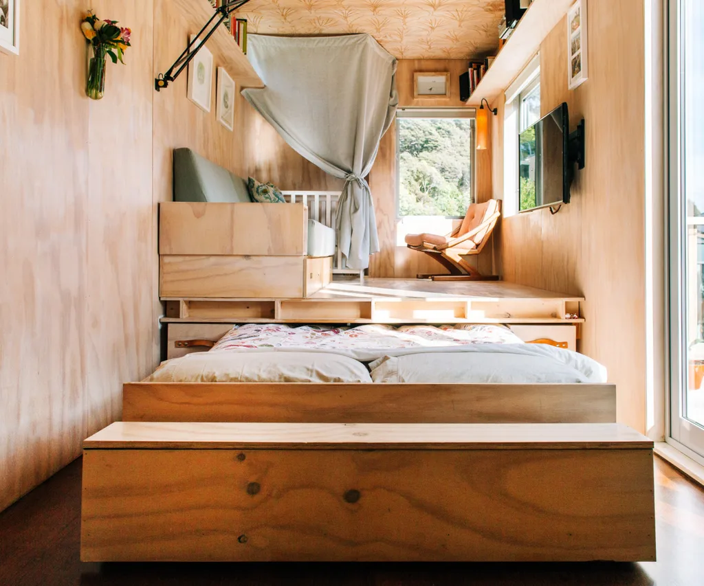 A pull-out bed under the lounge in the shipping container home
