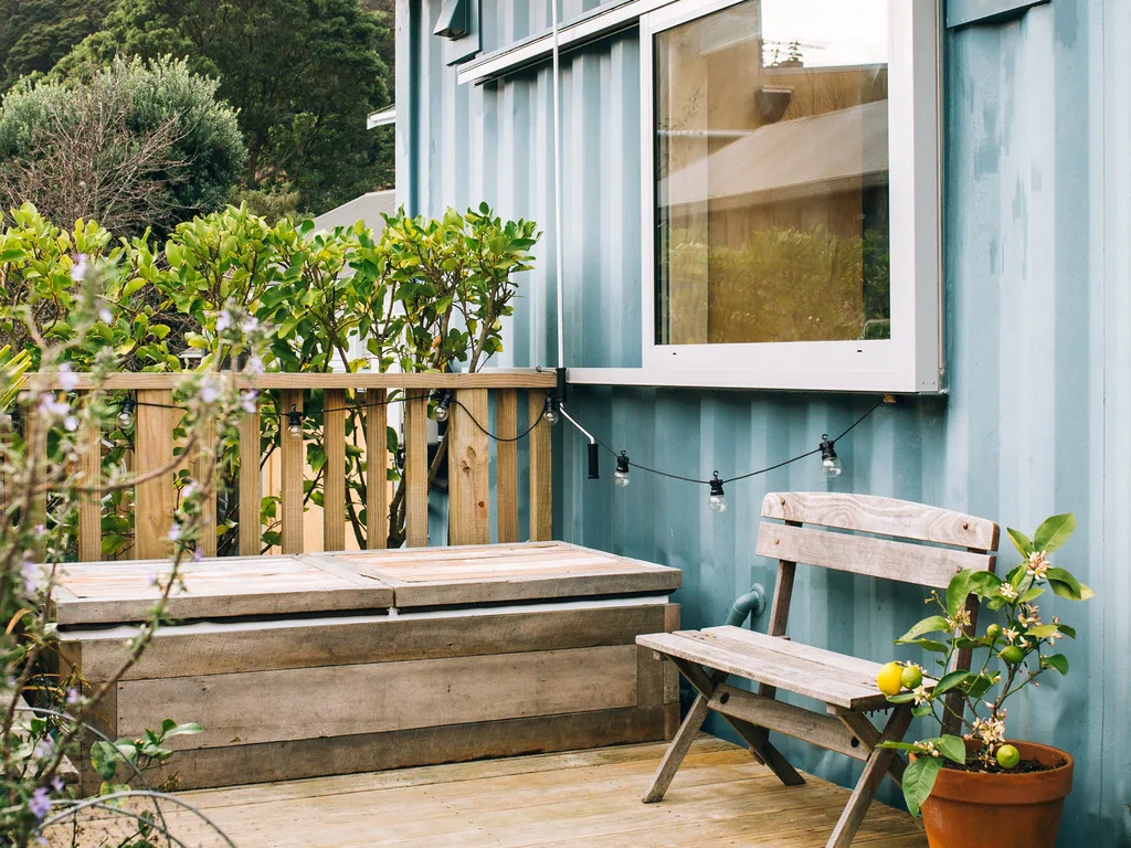The outdoor decking with a wooden chair and storage bench