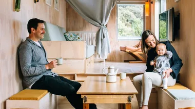 A couple and their baby in their shipping container home