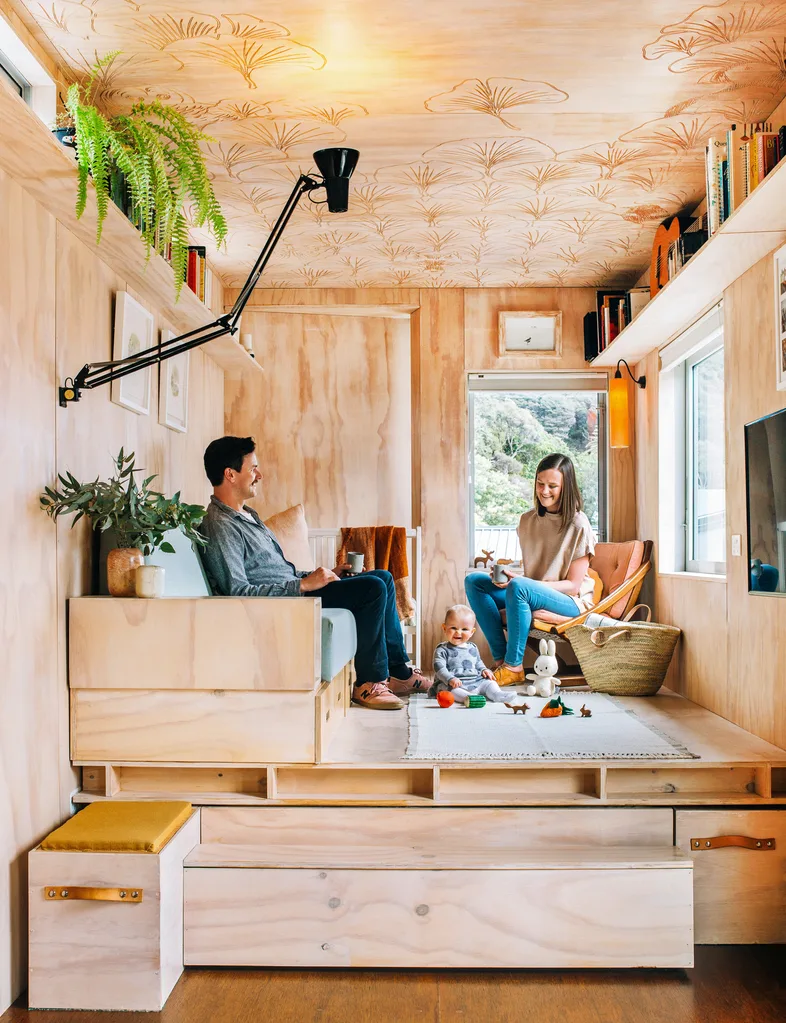 The shipping container home owners playing with their baby in the lounge