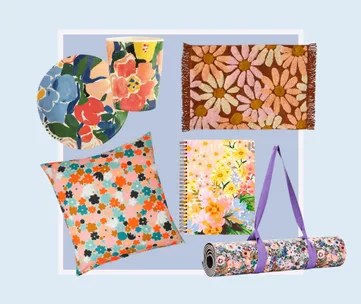 Floral-themed items: pillow, plate, cup, rug, notebook, and rolled yoga mat with purple strap on light blue background.