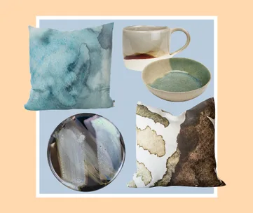 Home decor items: abstract pillows, ceramic mug, bowl, and plate on a light blue background with beige border.