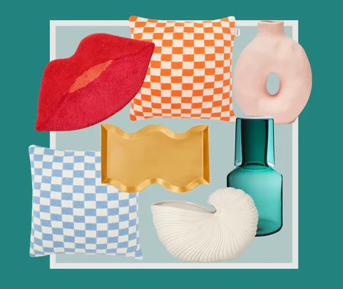 Home decor items: red lips pillow, orange and blue checkered pillows, abstract vase, wavy tray, green bottle, seashell vase.