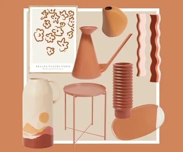 Assorted home decor items in earthy tones, including a vase, watering can, candles, table, and art print.