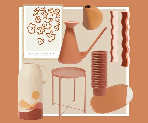 Assorted home decor items in earthy tones, including a vase, watering can, candles, table, and art print.