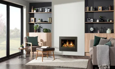 Modern living room with a fireplace, armchair, and bookshelves, featuring plants and decorative items.