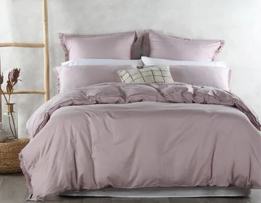 Lavender bedding set on a neatly made bed with decorative pillows and a rustic ladder beside.
