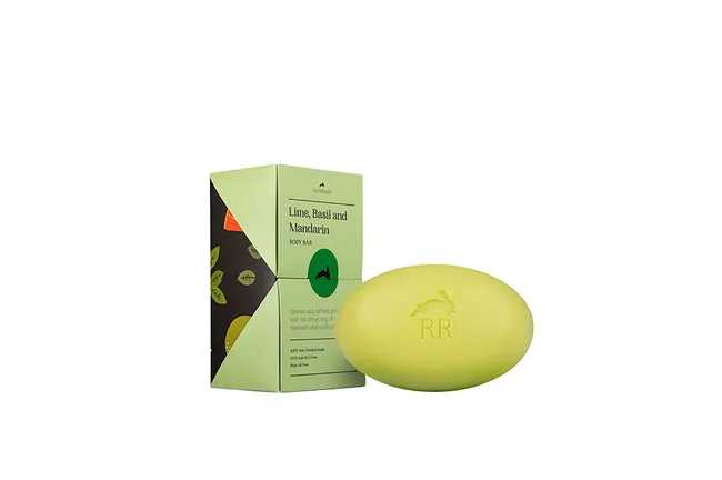 Lime, basil, and mandarin body bar soap with packaging featuring leaf design. Embossed logo on the soap.