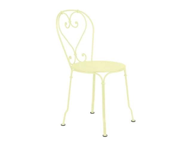 Pale yellow metal chair with a heart-shaped backrest and decorative details.